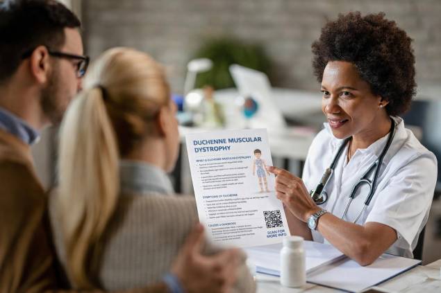 Doctor showing patients an educational handout with a QR code in the exam room